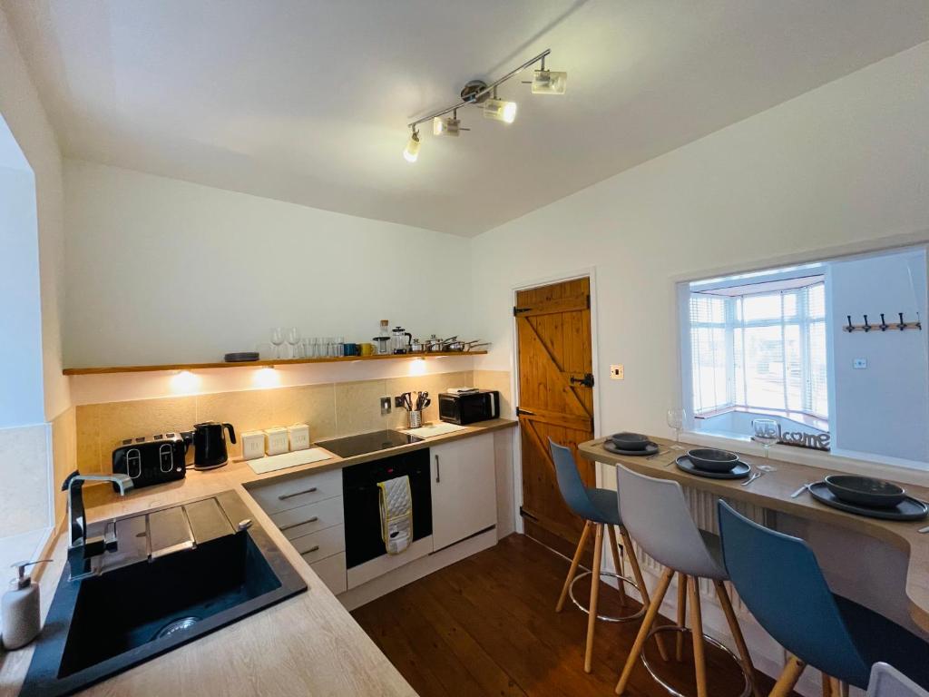 a kitchen with a table and two bar stools at New North House by Staytor Accommodation in Exeter