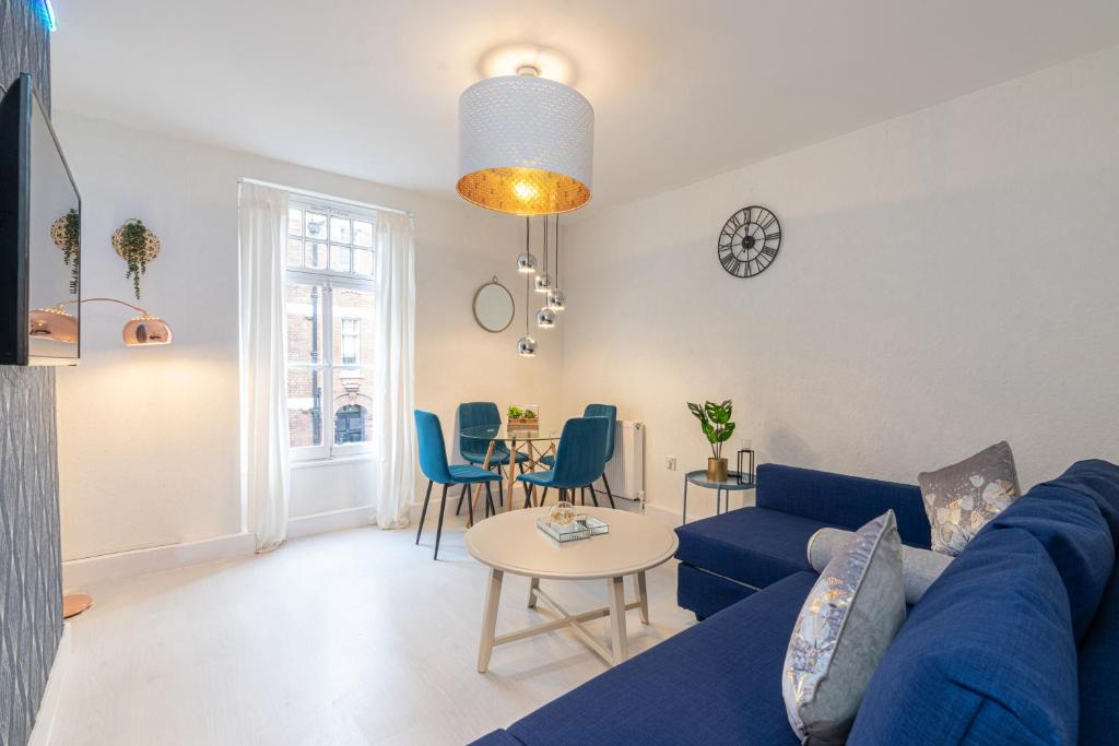 Stunning 2 Bedrooms Apartment Next Door To Selfridges and Oxford Street في لندن: غرفة معيشة مع أريكة زرقاء وطاولة