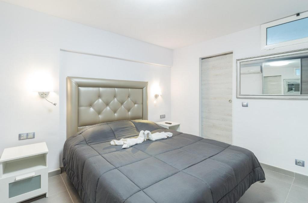 a bedroom with a large bed with two white animals on it at Holiday Home Alexia Oceanfront in San Bartolomé de Tirajana