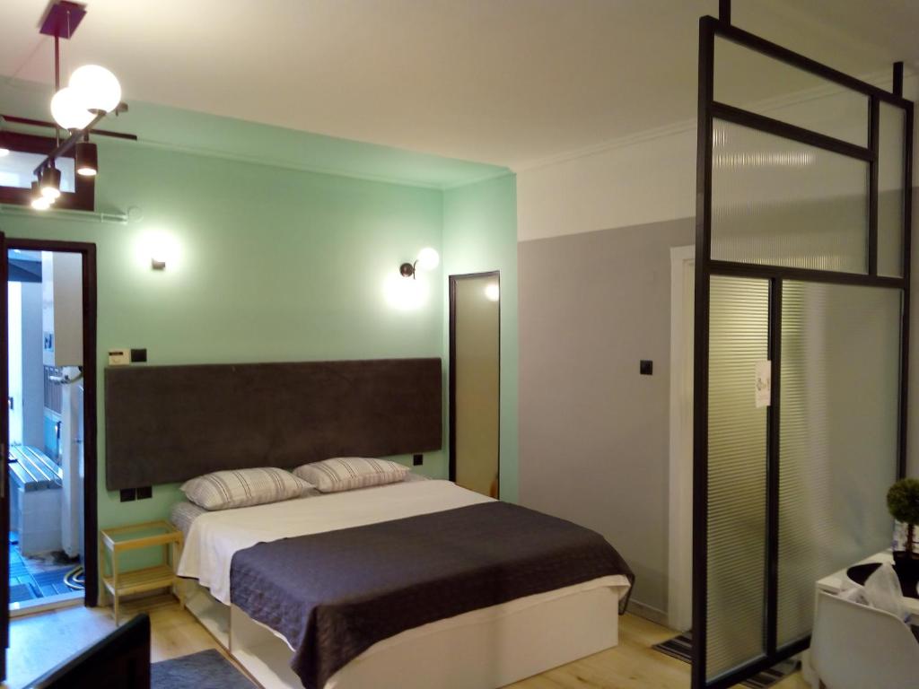 - une chambre avec un lit et un mur vert dans l'établissement Agias Sofias Square Stunning suite, à Thessalonique