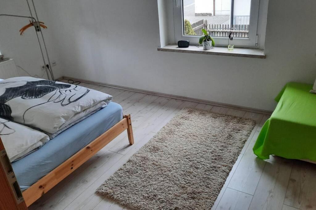 Schlafzimmer mit einem Bett, einem Fenster und einem Teppich in der Unterkunft Gemütliche Whg in Einsiedel am Rande der Zwönitz in Chemnitz