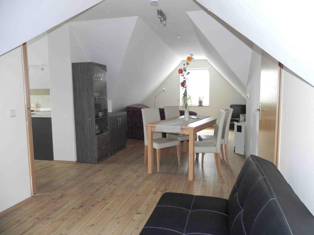 a dining room and living room with a table and chairs at Ferienwohnungen am Unstrutwehr in Freyburg