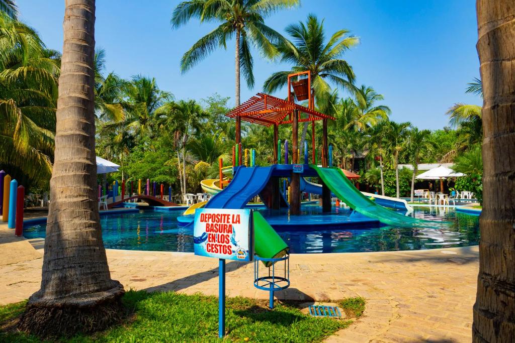 a swimming pool with a slide at a resort at Balneario y Cabañas ISIS in La Huerta