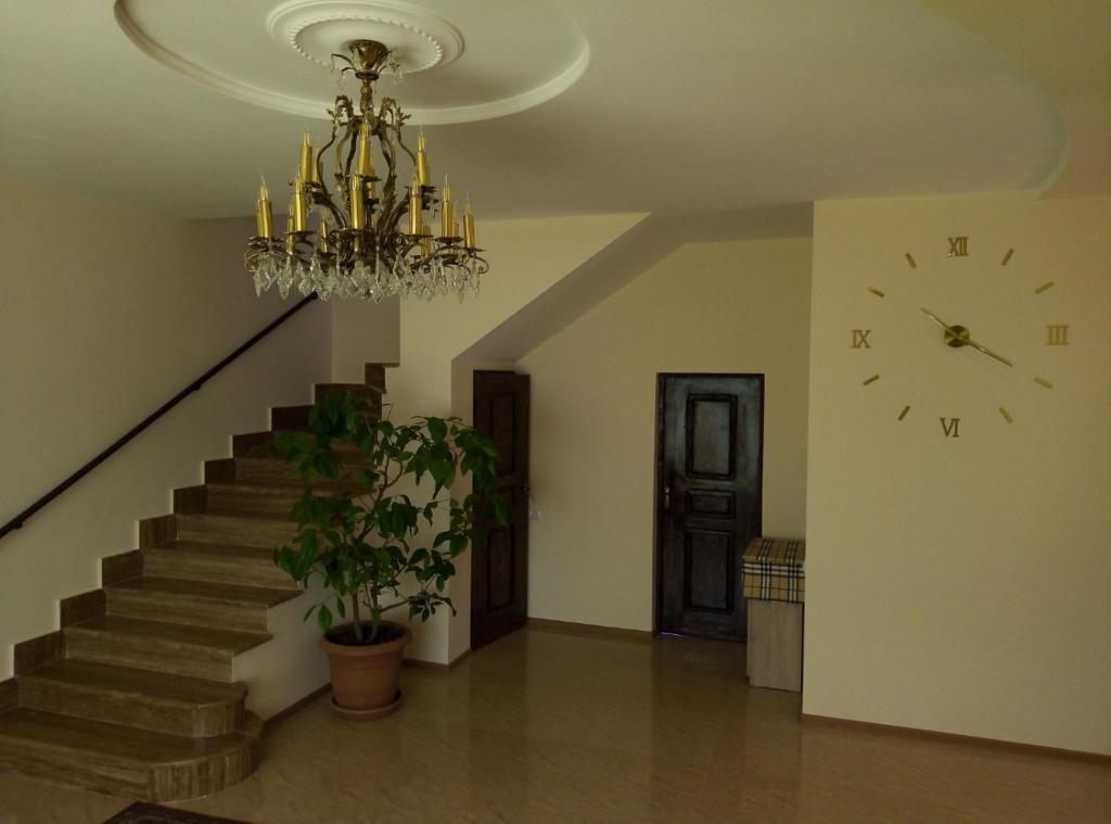 a room with a chandelier and a clock on the wall at Garni family house B&B in Garni