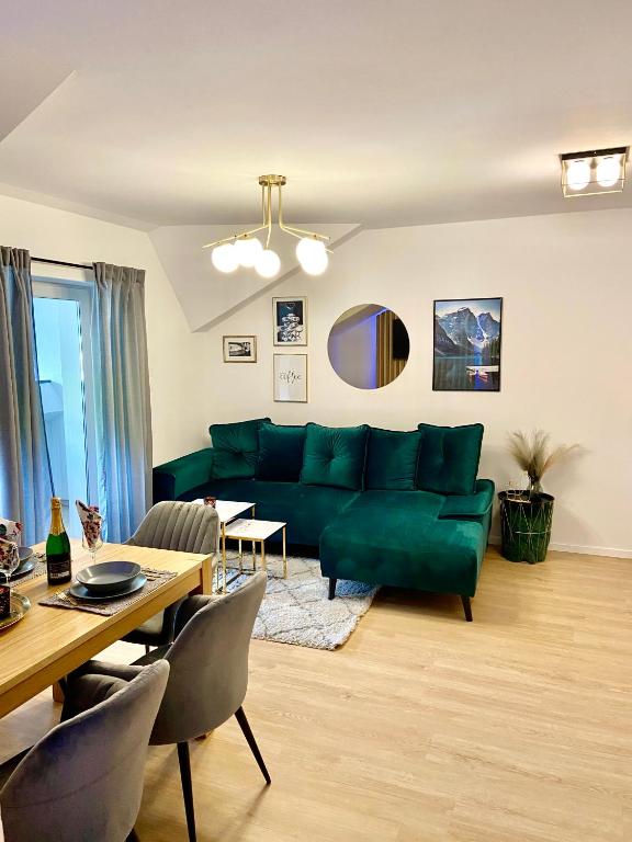 a living room with a green couch and a table at Apartmán Klára in Terchová