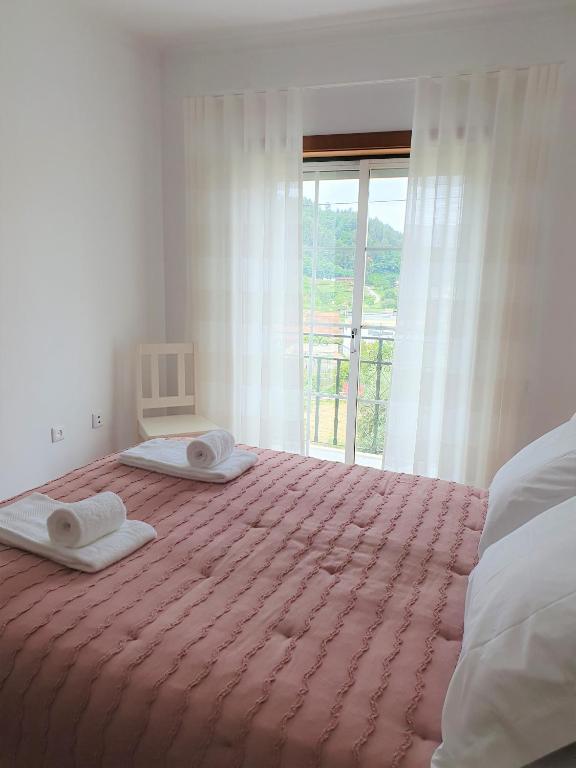 a bedroom with a bed with two towels on it at Lousã's Brown & White in Lousã