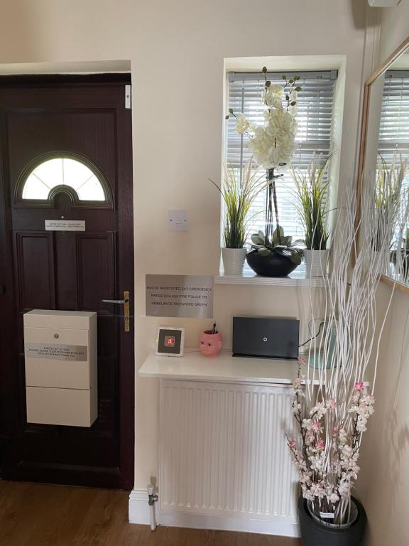 una habitación con una puerta y algunas plantas y flores en Kensal Lodge Guest House en Londres