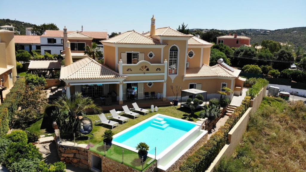 une vue aérienne d'une maison avec piscine dans l'établissement Casa Das Palmeiras, à Loulé