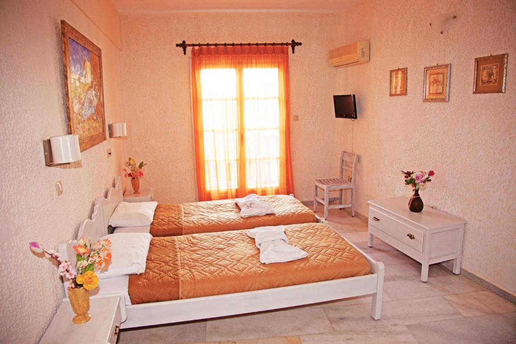 a bedroom with two beds and a window at St.George Valsamitis in Katapola