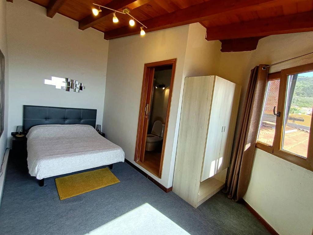 a small bedroom with a bed and a mirror at Apartamento Maudes de StarApsTenerife in Sauzal