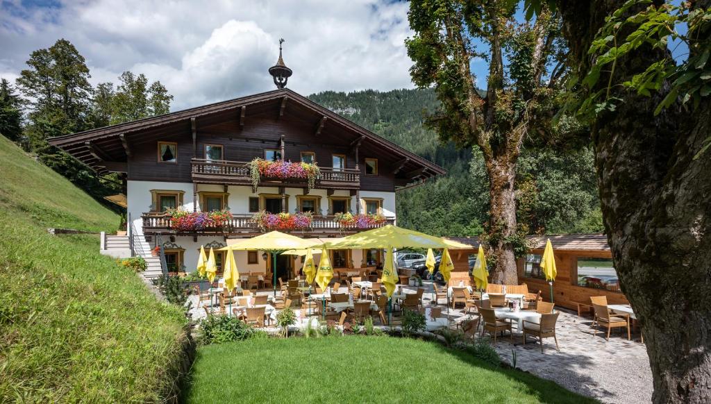 Gasthof Oberstegen في سول: مبنى امامه طاولات وكراسي
