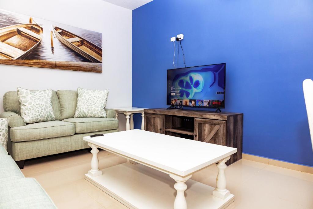een woonkamer met een bank en een tv bij Bella Vista 15 in Puerto Peñasco