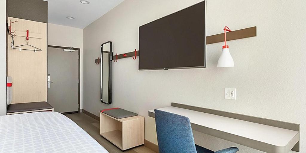 a room with a bed and a tv on the wall at avid hotels - Zeeland by IHG in Holland