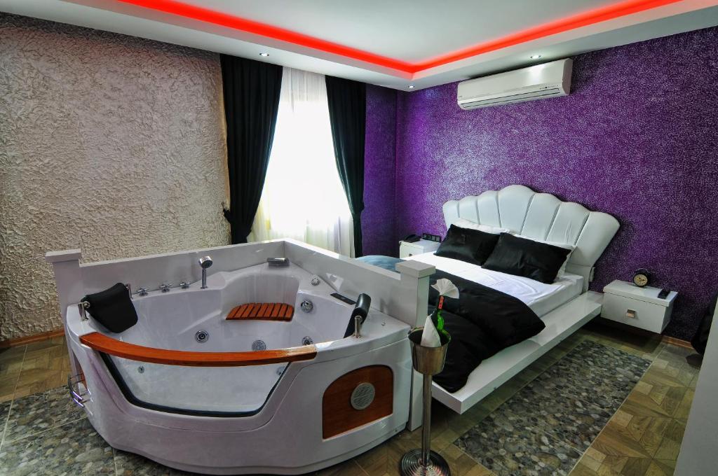 een slaapkamer met een bed en een bad. bij Ag Şişli Hotel in Istanbul