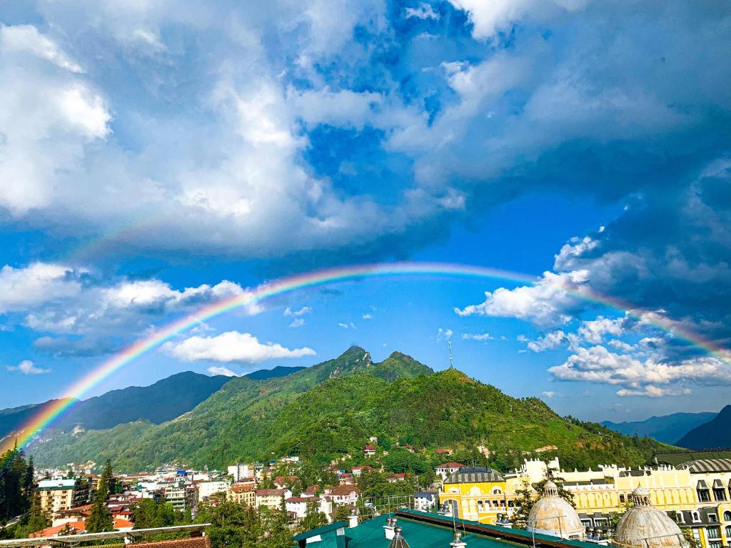 een regenboog in de lucht boven een stad bij The 1996 House in Lao Cai