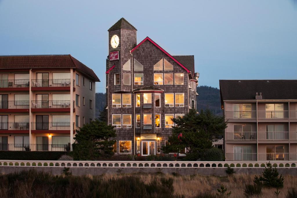 un edificio con una torre de reloj frente a dos edificios en The Seaside Oceanfront Inn, en Seaside