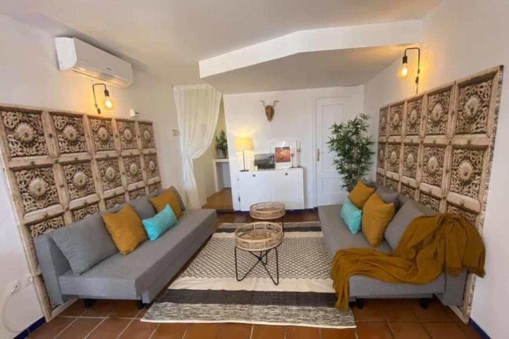 ein Wohnzimmer mit einem Sofa und einem Tisch in der Unterkunft Apartamento Rocio Donaña Matalascañas in El Rocío
