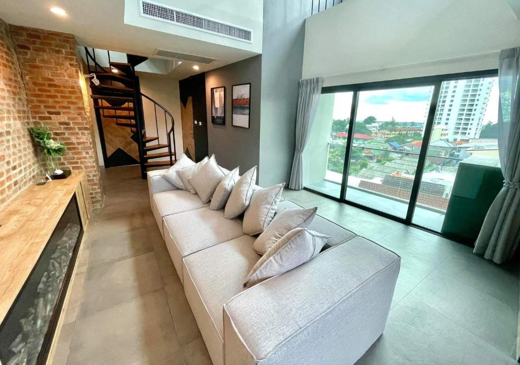 un soggiorno con divano bianco e ampie finestre di Room Actually Service Apartment a Karon Beach