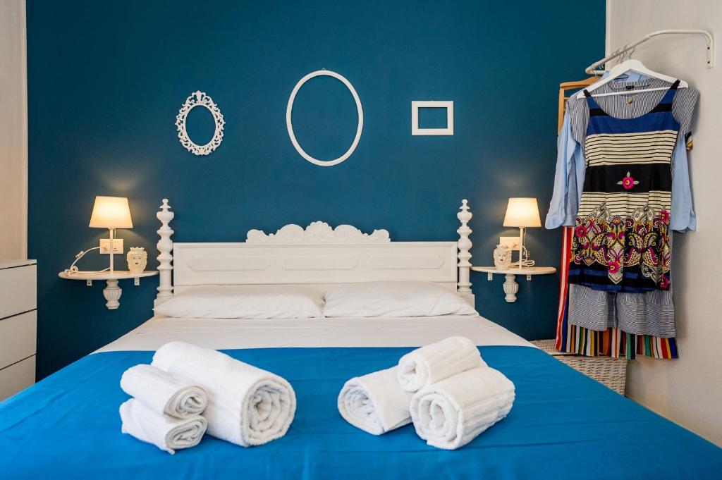 カステッランマーレ・デル・ゴルフォにあるLe Maiolicheの青いベッドルーム(タオル付きのベッド付)