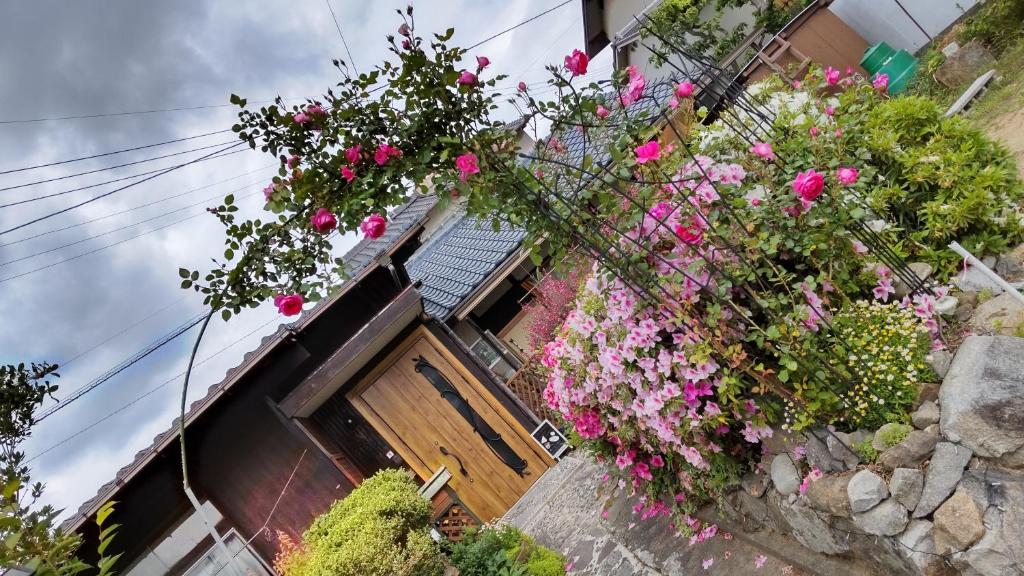 una casa con dei fiori sul lato di Guesthouse Yashima a Takamatsu