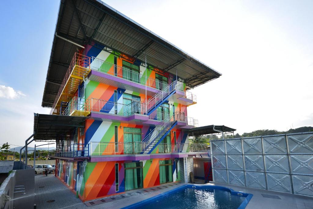 um edifício colorido com uma piscina em frente em Bahagia Villa em Kuah