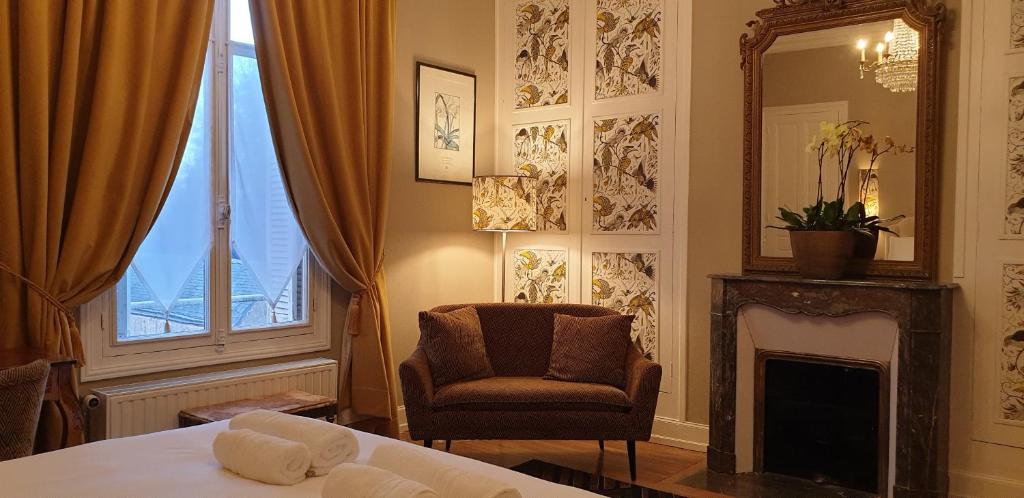 - une chambre avec un lit, une chaise et un miroir dans l'établissement LA MAISON LEONARD, à Bléré