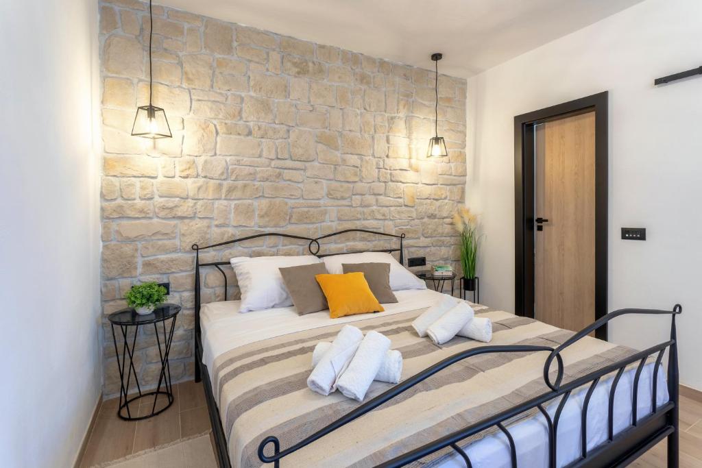 łóżko w pokoju z kamienną ścianą w obiekcie TEONA Luxury Studio Apartment with jacuzzi and terrace sea view w mieście Sali