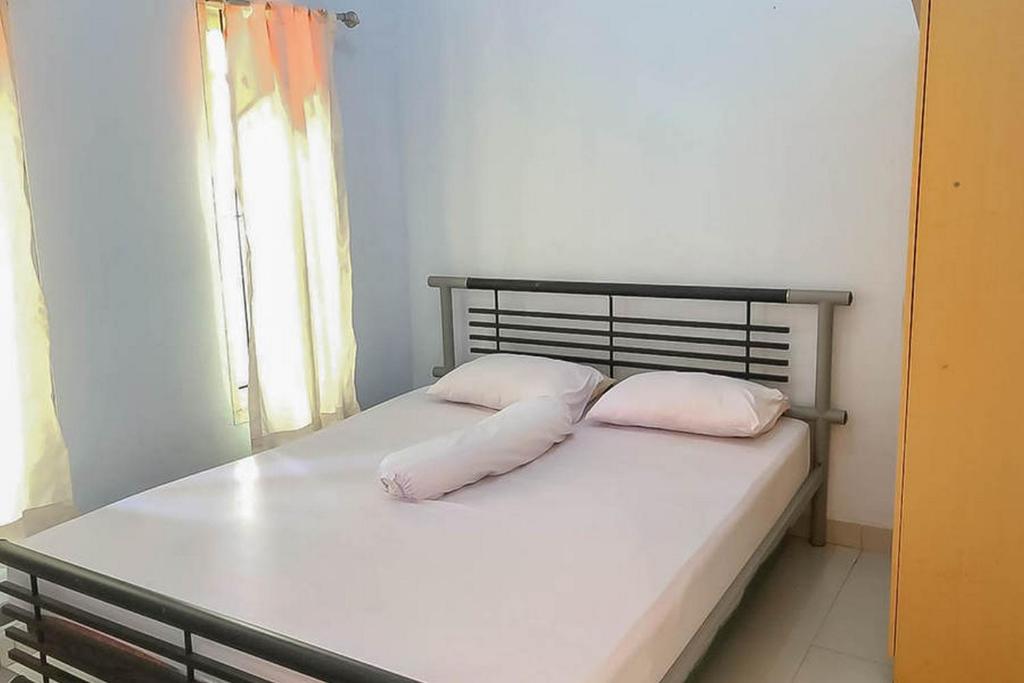 a bed with two pillows on it in a room at Taman Wisata Siwalk Cottage Syariah in Cirebon
