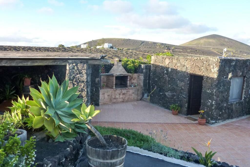 a stone house with a courtyard with a potted plant at Los Frailes Eco Finca B in Tinajo