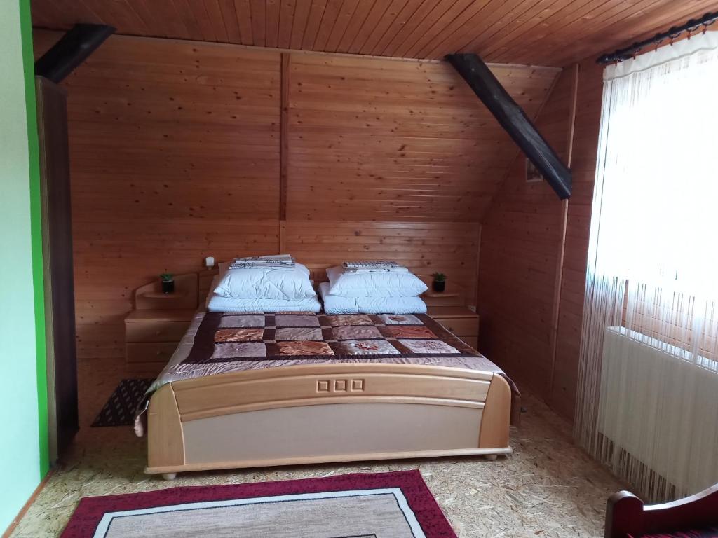 a bedroom with a bed in a wooden room at Gospodarstwo Agroturystyczne Aniela in Piecki