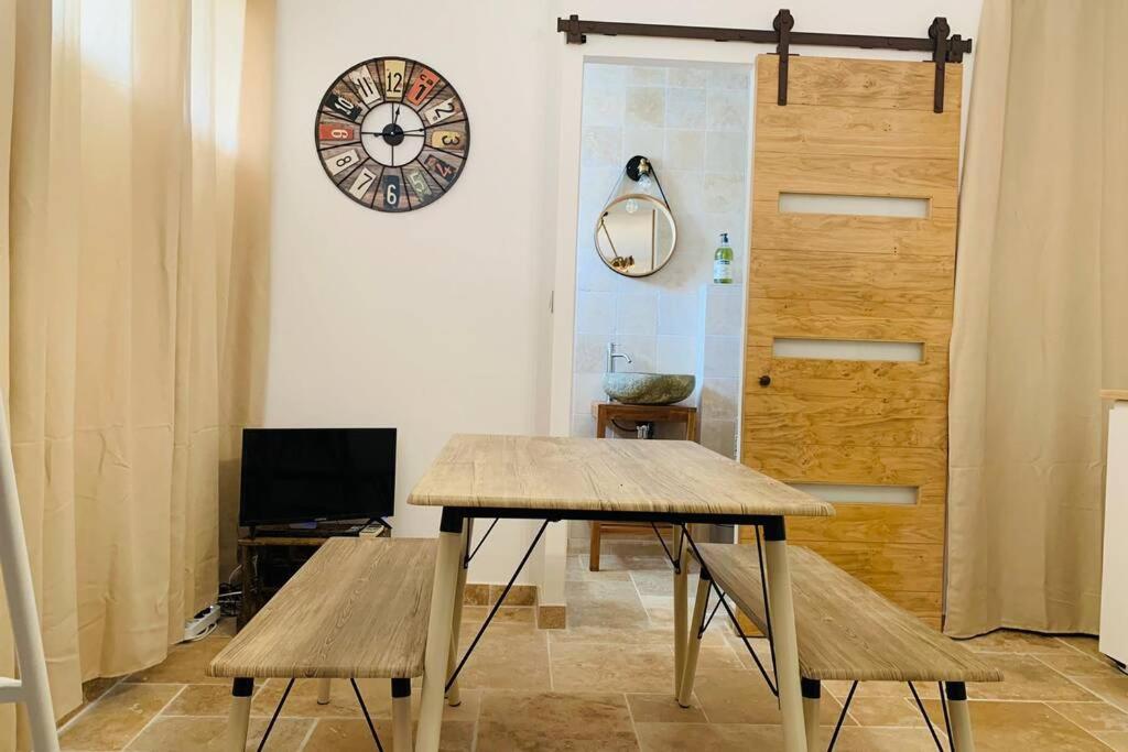 um quarto com uma mesa e um relógio na parede em studio centre de Hyeres ( 4 personnes ) em Hyères