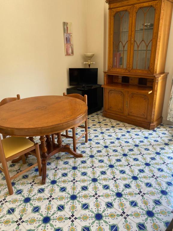 een eetkamer met een tafel en een kast bij Casa stile mediterraneo Piazza Durante a Letojanni Taormina in Letojanni