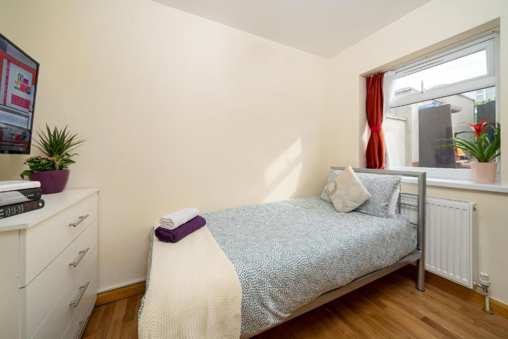 1 dormitorio con cama y ventana en Single Room G1 (Sandycroft Guest House), en Londres