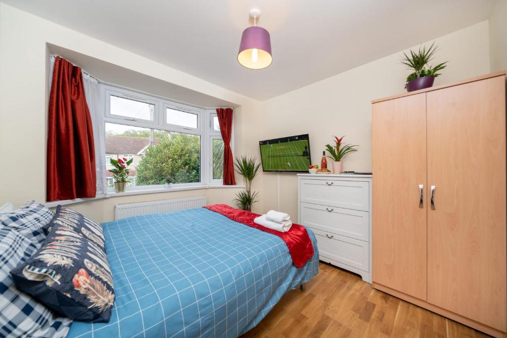 Un dormitorio con una cama azul y una ventana en Economy Double Room G2 (Sandycroft Guest House), en Londres