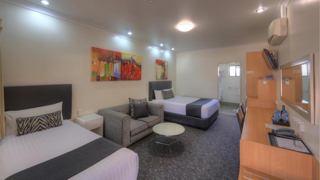 a hotel room with two beds and a couch at Best Western Ascot Lodge Motor Inn in Goondiwindi