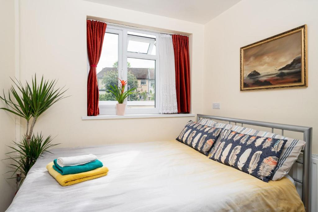 a bedroom with a bed and a window with red curtains at F5 Private Double Room (Sandycroft Guest House) in London