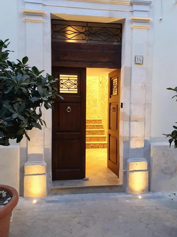 a brown door in a white building with a porch at Palazzo GiuFa in Syracuse