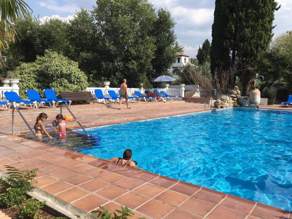 a group of children playing in a swimming pool at Camping Reina Isabel in La Zubia
