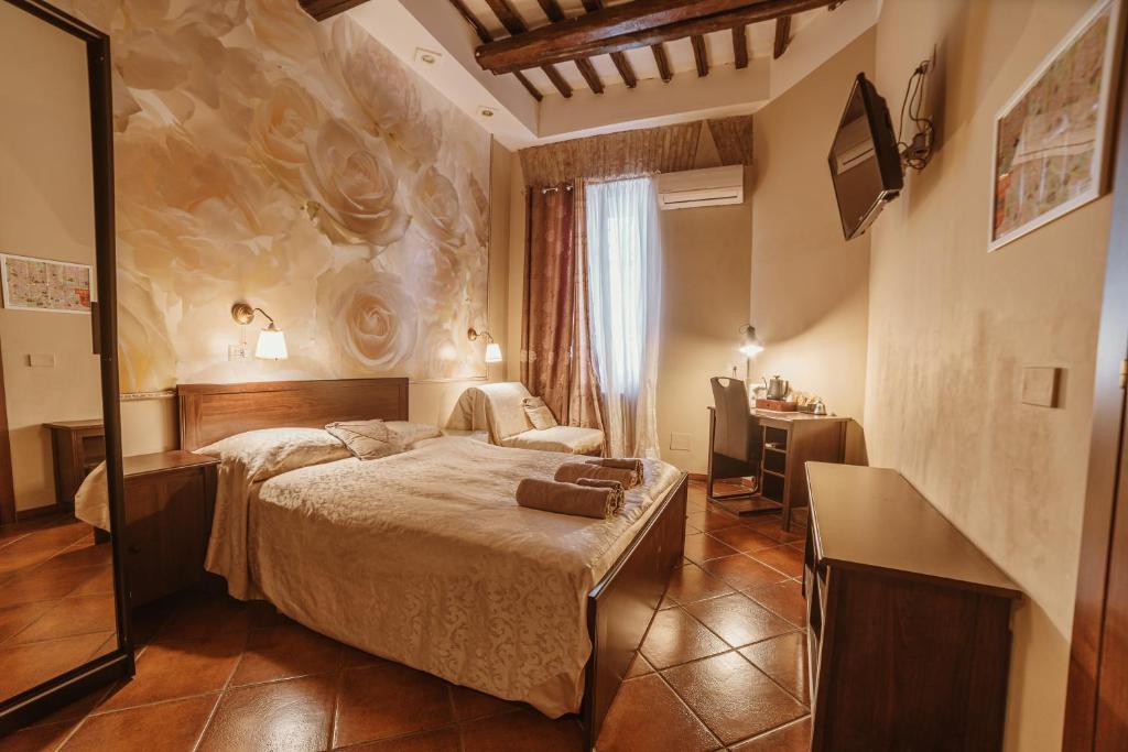 ローマにあるRonda St. Angelo Suitesのベッドとデスクが備わるホテルルームです。