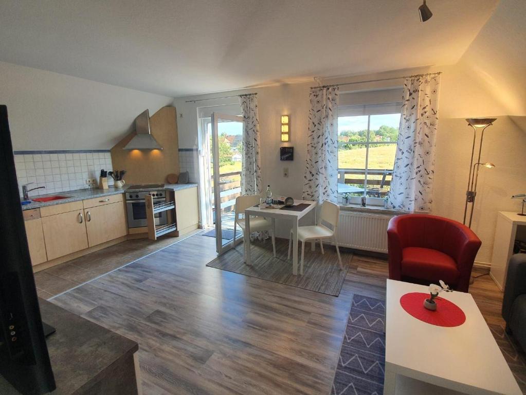 cocina y sala de estar con mesa y comedor. en Ferienwohnung-Tomme en Wulfen auf Fehmarn