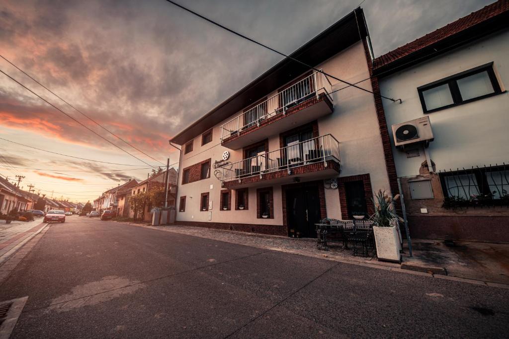 a building on a street with a sunset in the background at Penzion V Pohádce in Velké Pavlovice