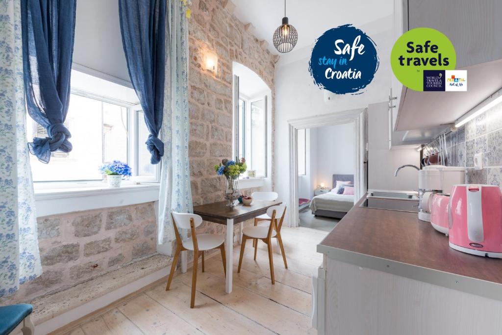 a kitchen with a table and chairs in a room at La Piazza Apartment in Dubrovnik