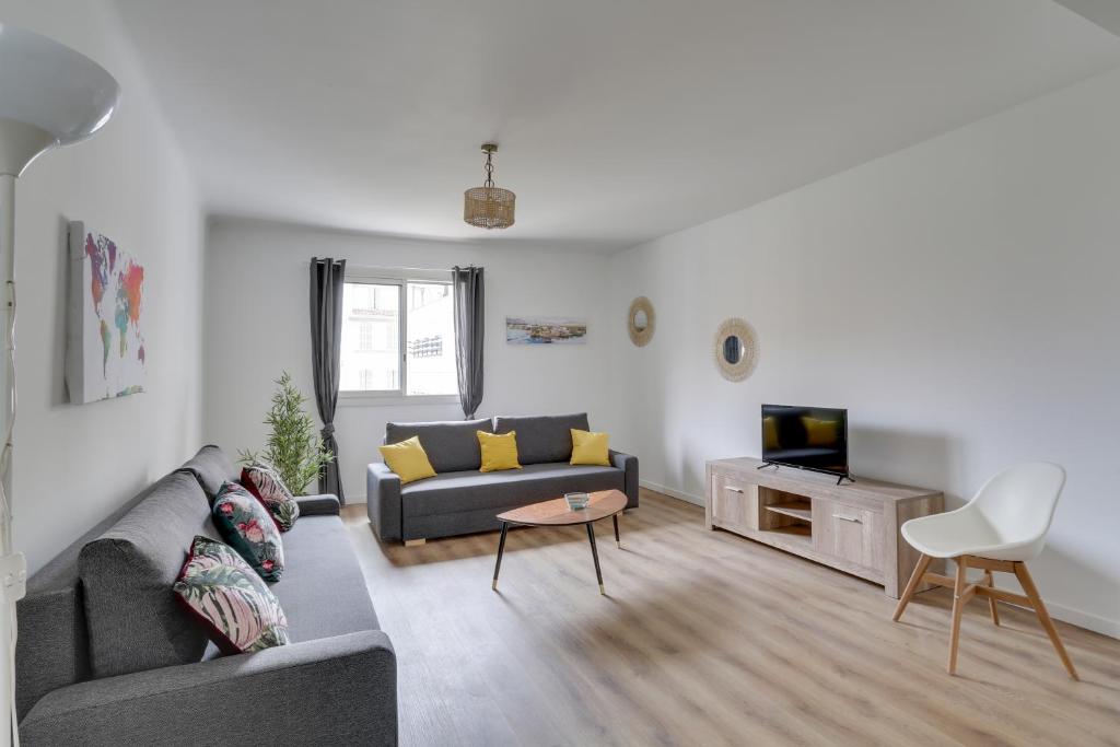 een woonkamer met een bank en een tv bij Magnifique T5 (12pers) 129m²-Climatisé-Vieux-Port in Marseille