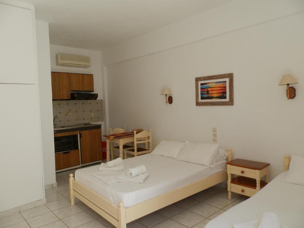 a small bedroom with a bed and a kitchen at Aeolos Hotel Apartments in Gythio