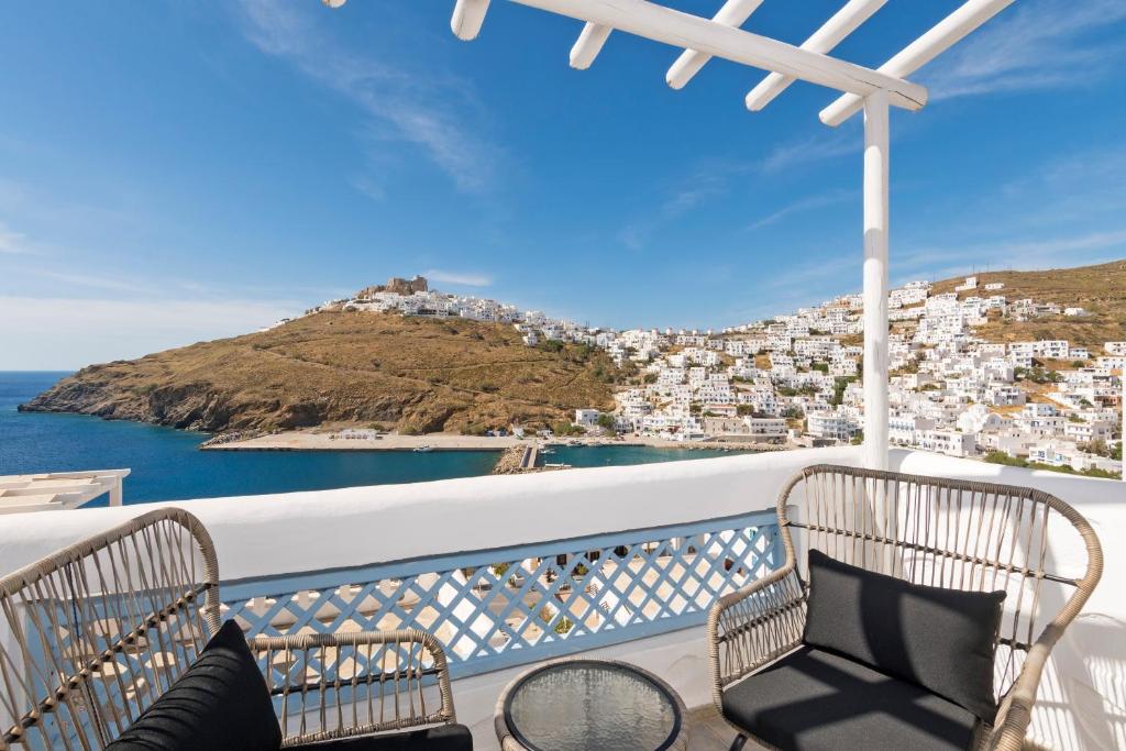 a balcony with chairs and a view of the ocean at Ihthioessa Boutique Hotel in Astypalaia