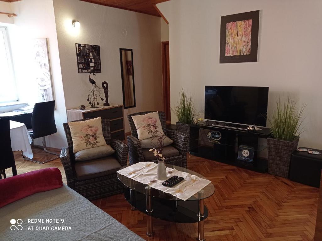 een woonkamer met een tafel en een televisie bij Apartment Piazza Antica in Rovinj