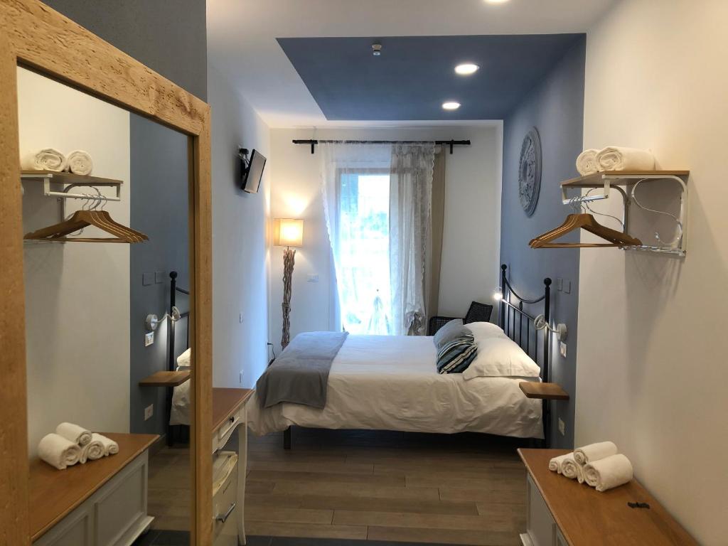 1 dormitorio con cama, ventana y espejo en Ca' del Monica, en Manarola