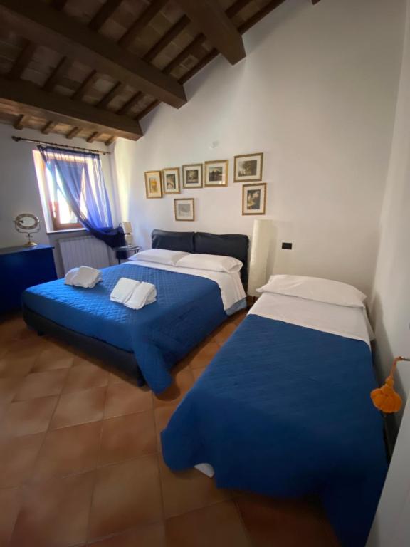 dwa łóżka w pokoju z niebieskim i białym w obiekcie Osimo Caves Rooms w mieście Osimo