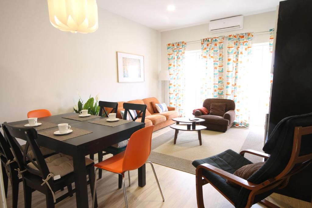 - un salon avec une table et des chaises noires dans l'établissement Quinta das Conchas Apartment by Trip2Portugal, à Lisbonne