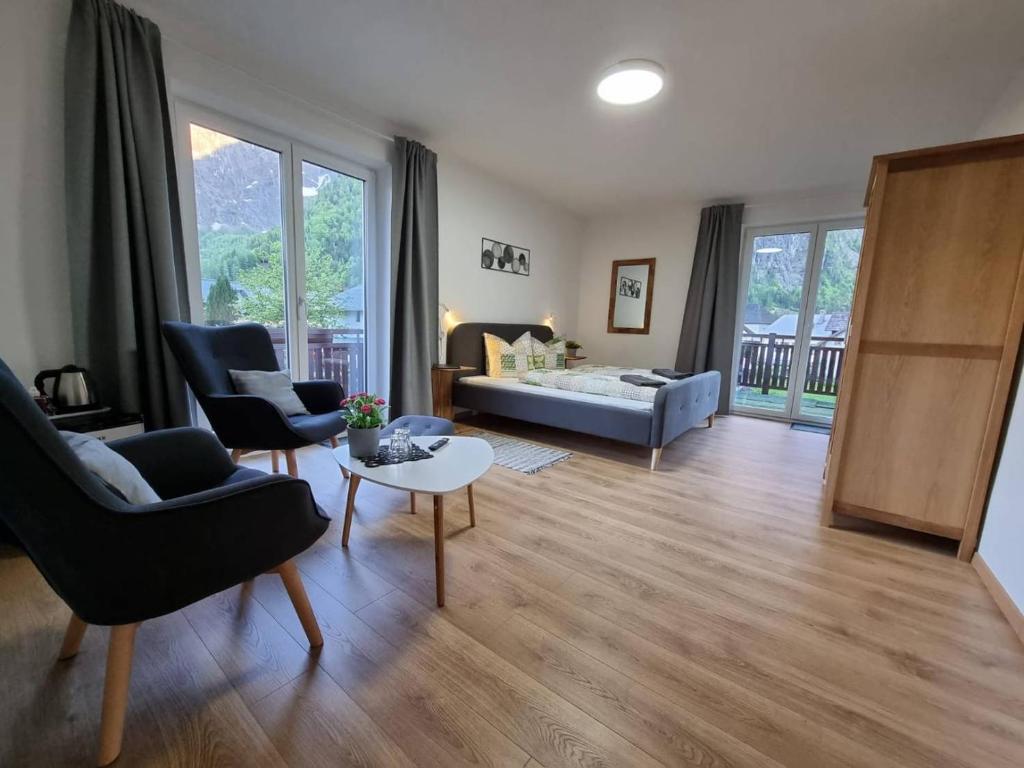 uma sala de estar com um sofá, cadeiras e uma mesa em Pension Bergfried em Hallstatt